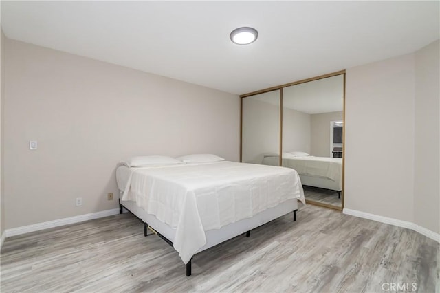 bedroom with light hardwood / wood-style flooring and a closet