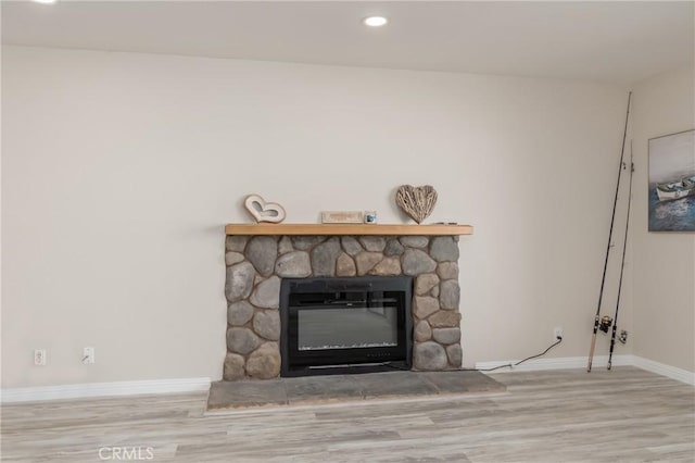 interior details featuring hardwood / wood-style flooring and a stone fireplace