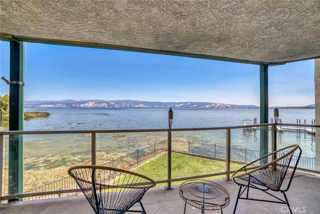 balcony featuring a water and mountain view