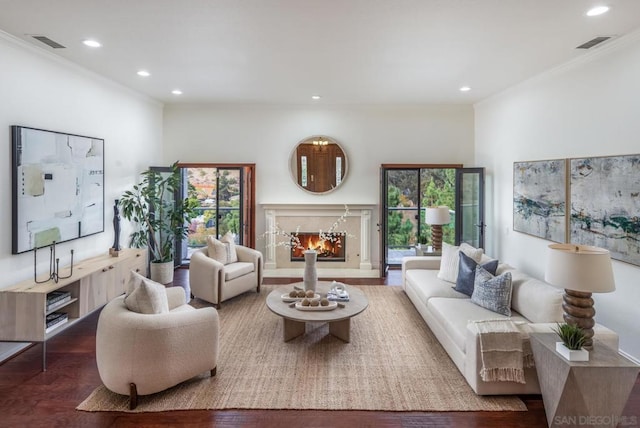 living room with a premium fireplace, hardwood / wood-style floors, and crown molding