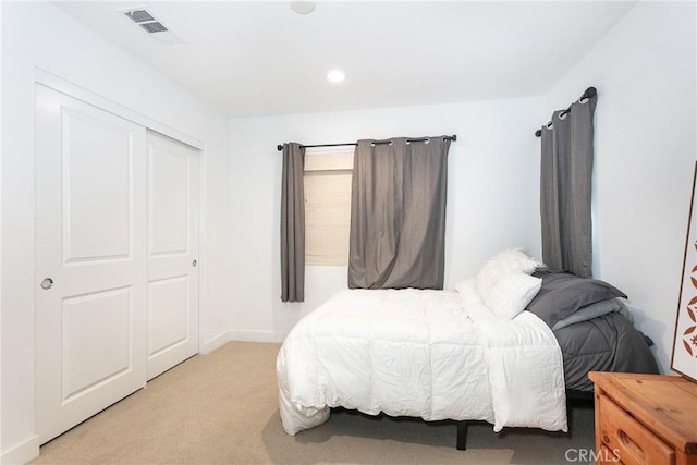 bedroom with light carpet and a closet