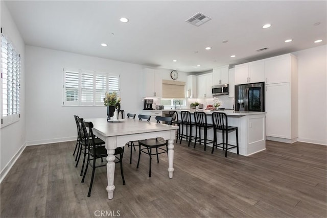 dining room featuring dark wood-type flooring and sink