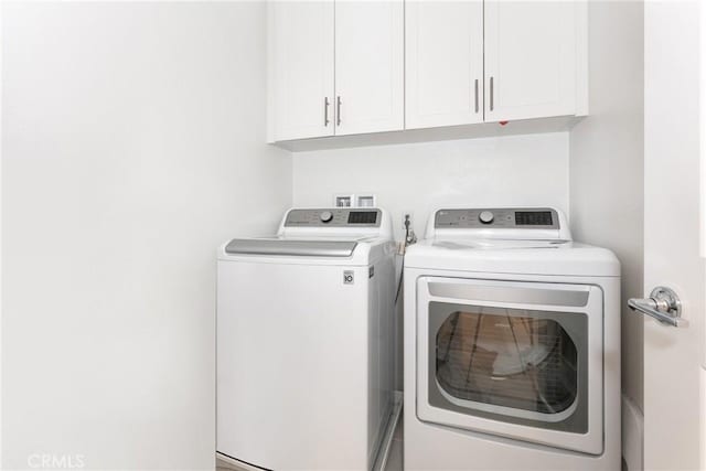 washroom featuring washer and dryer and cabinets