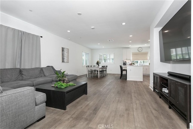 living room with light hardwood / wood-style floors and sink