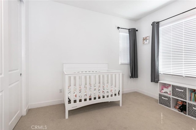 carpeted bedroom featuring a crib