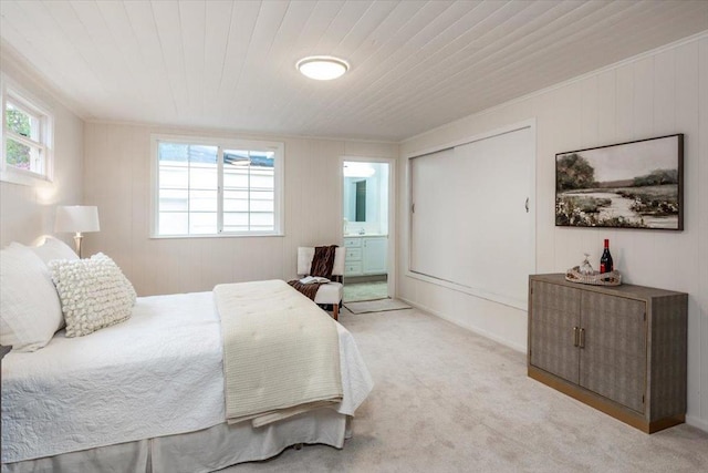 carpeted bedroom featuring crown molding, wooden ceiling, multiple windows, and ensuite bath