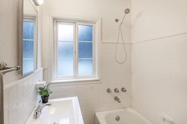 bathroom with sink, a wealth of natural light, and tiled shower / bath