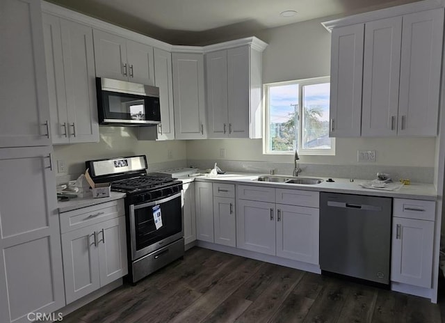 kitchen with white cabinetry, sink, stainless steel appliances, and dark hardwood / wood-style floors