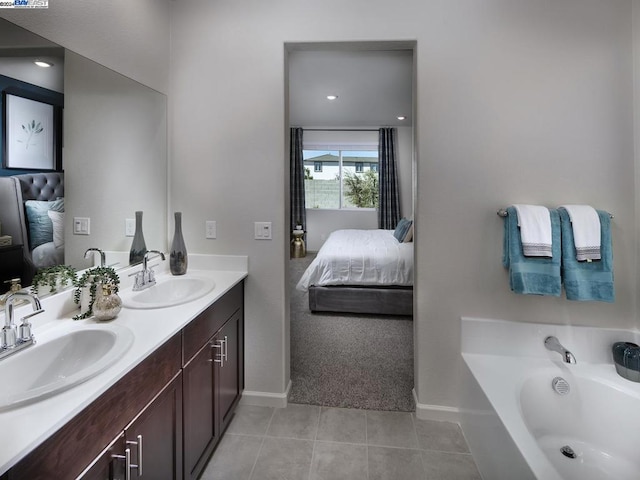 bathroom featuring tile patterned floors, a tub to relax in, and vanity