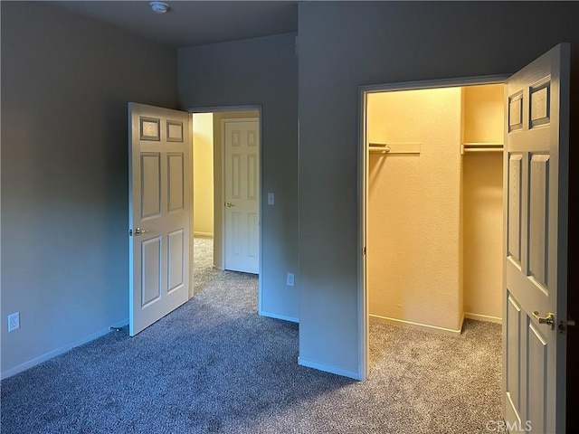 unfurnished bedroom featuring a walk in closet, a closet, and carpet