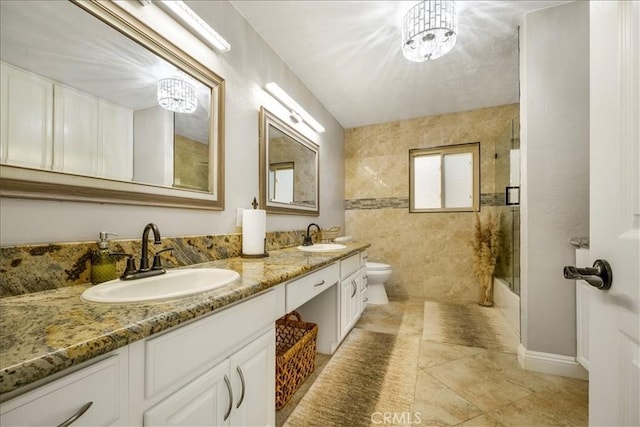 full bathroom featuring vanity, combined bath / shower with glass door, tile patterned flooring, toilet, and a notable chandelier