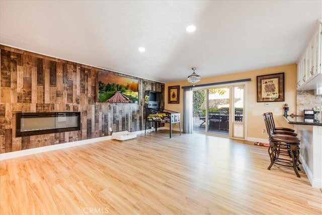 living room featuring light wood-type flooring and wood walls