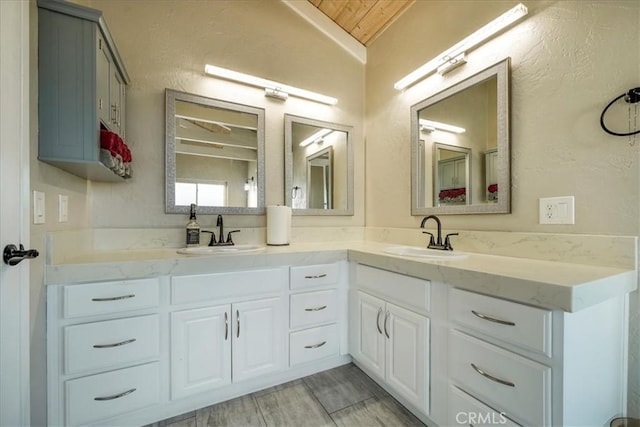 bathroom featuring vanity, wood ceiling, and vaulted ceiling