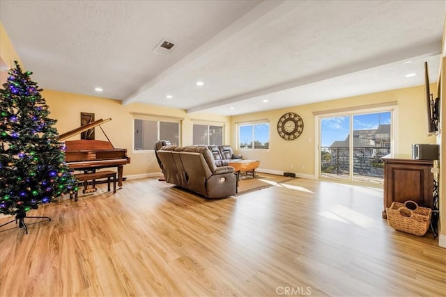 living room featuring beam ceiling and light hardwood / wood-style flooring