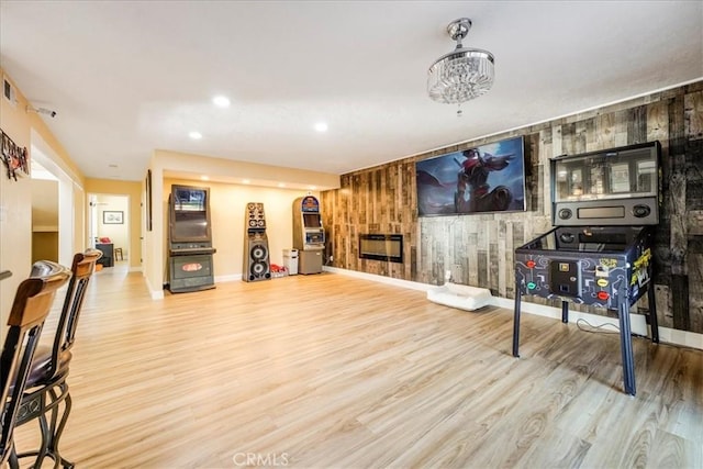 living room with a fireplace, hardwood / wood-style floors, and wooden walls