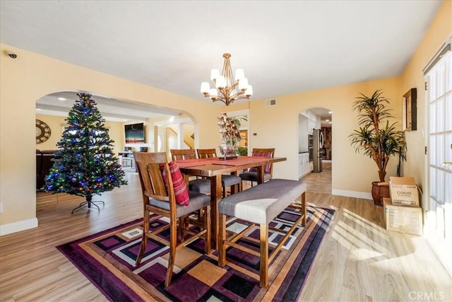 dining area with a notable chandelier and light wood-type flooring