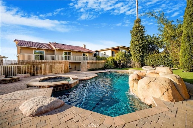 view of swimming pool featuring pool water feature, an in ground hot tub, and a patio