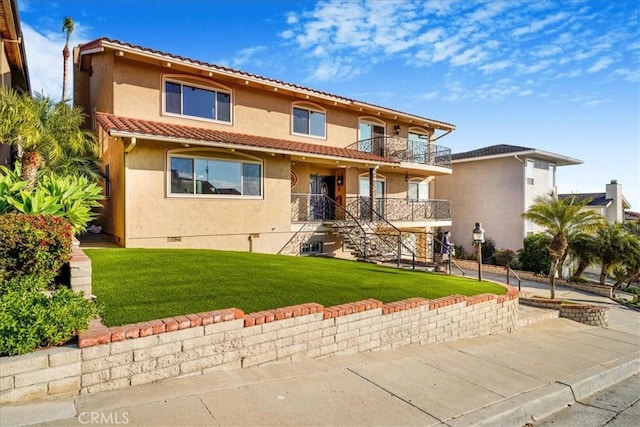 mediterranean / spanish home featuring a balcony and a front lawn