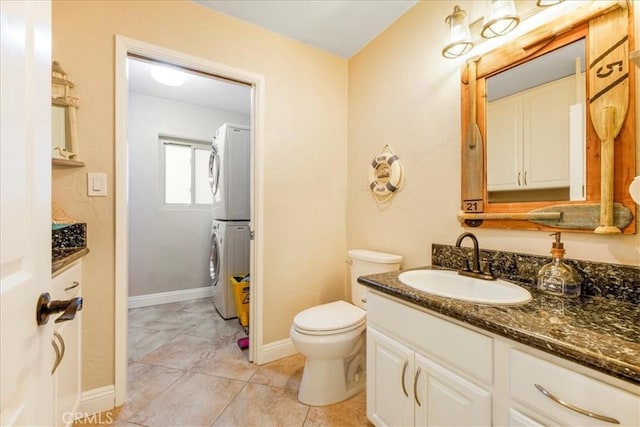 bathroom featuring tile patterned floors, vanity, stacked washing maching and dryer, and toilet