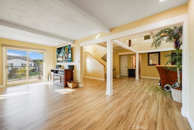 living room featuring beam ceiling and light wood-type flooring