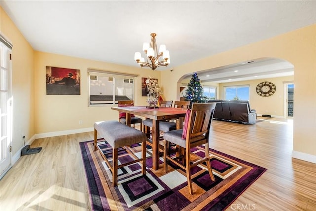 dining area with a notable chandelier and light hardwood / wood-style flooring