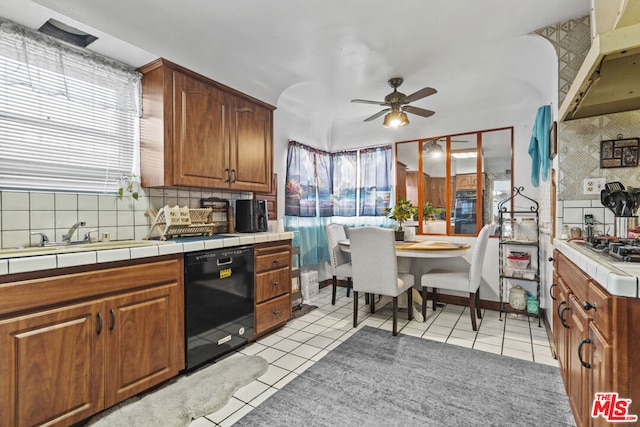 kitchen with tile countertops, ceiling fan, dishwasher, and light tile patterned floors