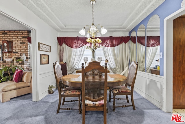 dining area featuring carpet flooring, a textured ceiling, and an inviting chandelier