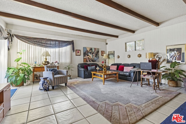 tiled living room featuring beam ceiling and a textured ceiling