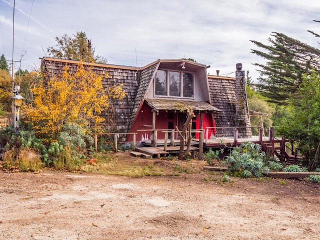 rear view of property featuring a wooden deck