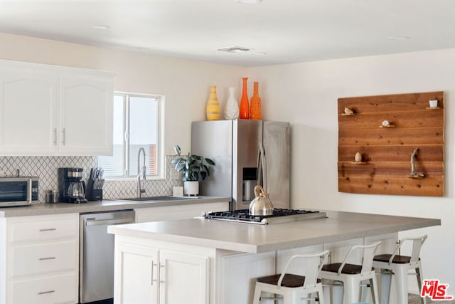 kitchen featuring white cabinets, a kitchen breakfast bar, and stainless steel appliances