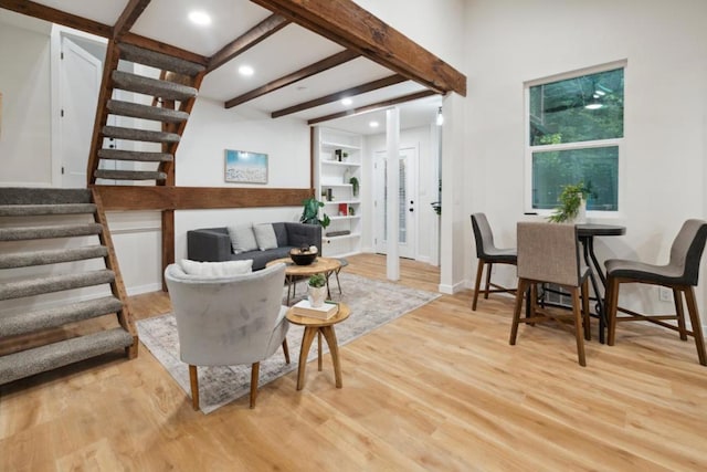 living room with beam ceiling and light hardwood / wood-style flooring