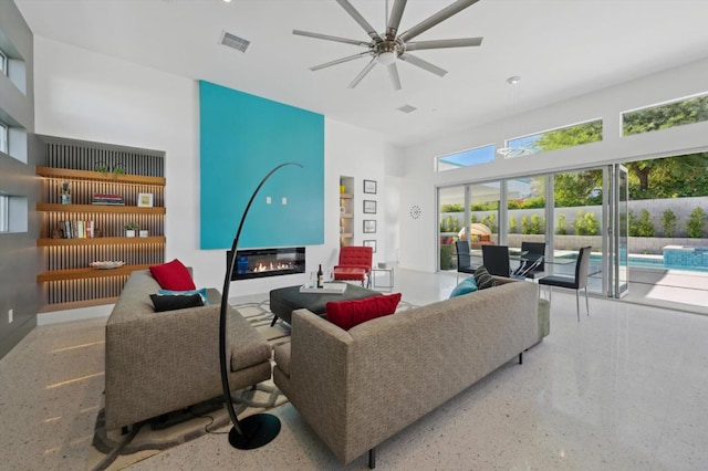 living room with a high ceiling and ceiling fan