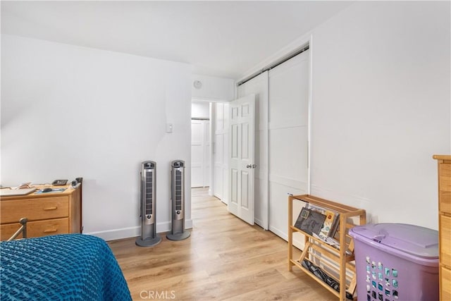 bedroom with light wood-type flooring and a closet