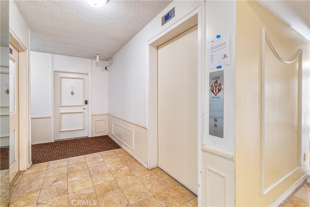 hall featuring a textured ceiling