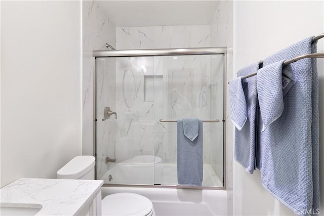 full bathroom featuring toilet, enclosed tub / shower combo, and vanity