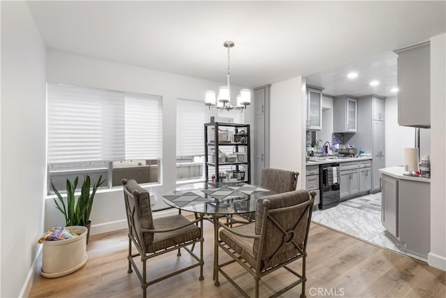 dining room with wine cooler, light hardwood / wood-style flooring, and an inviting chandelier