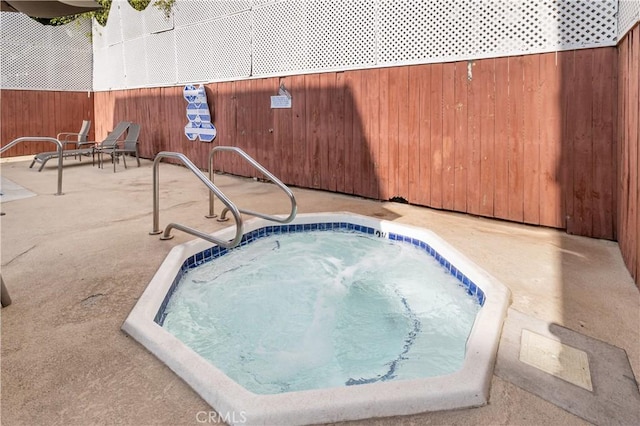 view of swimming pool featuring a hot tub