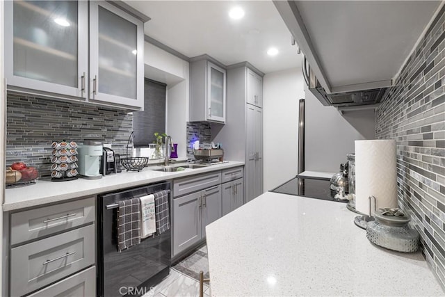 kitchen with light stone countertops, black dishwasher, sink, backsplash, and gray cabinets