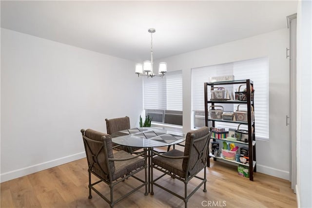 dining area with plenty of natural light, a chandelier, and light hardwood / wood-style flooring