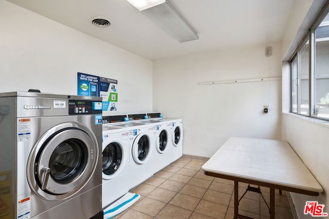 clothes washing area with light tile patterned flooring and independent washer and dryer