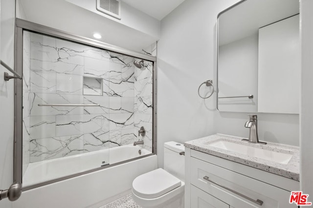 full bathroom with vanity, toilet, and bath / shower combo with glass door