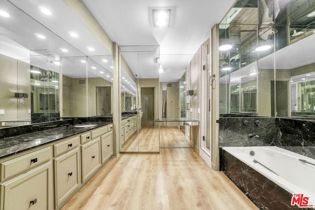 bathroom featuring hardwood / wood-style floors, vanity, and independent shower and bath