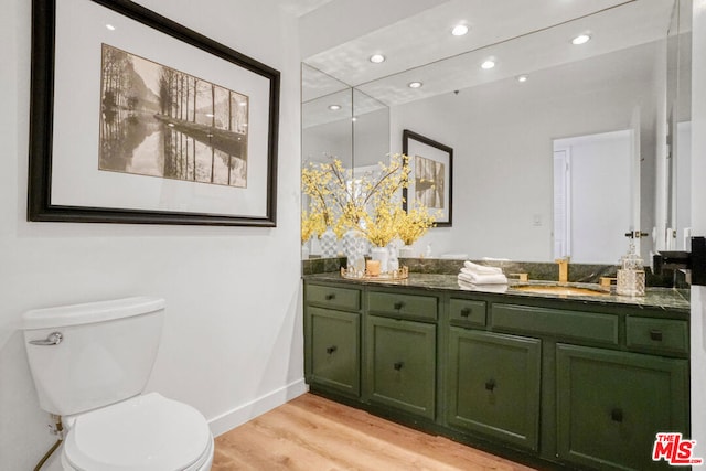 bathroom featuring wood-type flooring, vanity, and toilet