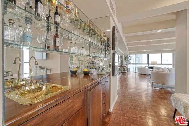 bar featuring beam ceiling, parquet floors, and sink