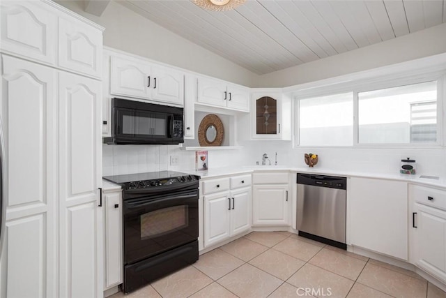 1809 W Bay Ave, Newport Beach, CA 92663 - kitchen featuring vaulted ceiling, backsplash, white cabinetry, light tile patterned flooring, and black appliances