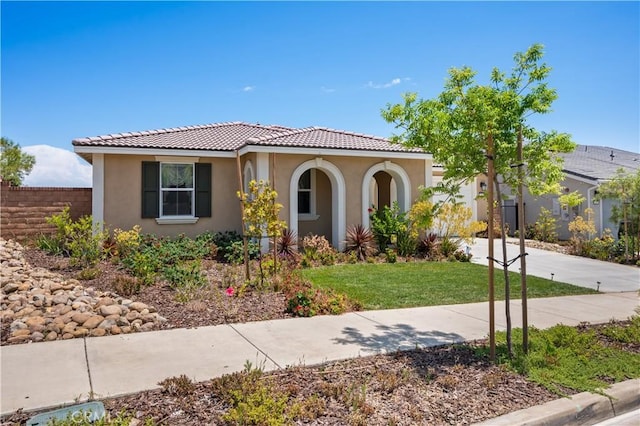 mediterranean / spanish house with a front lawn