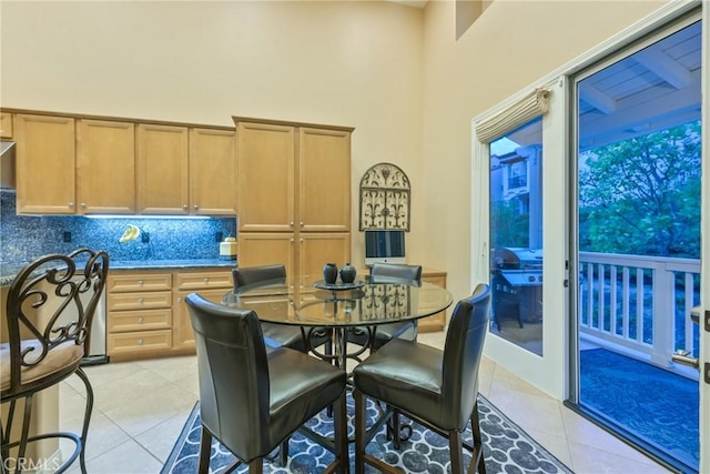 dining room with light tile patterned floors and a high ceiling