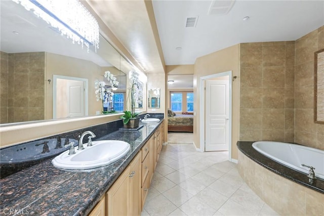 bathroom with tiled bath, tile patterned flooring, vanity, and tile walls