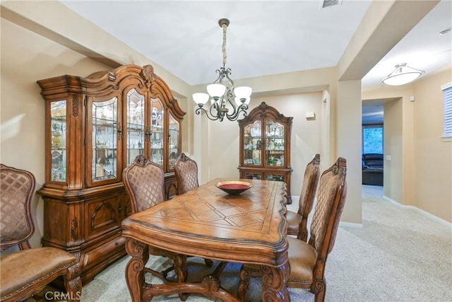 carpeted dining area featuring a chandelier