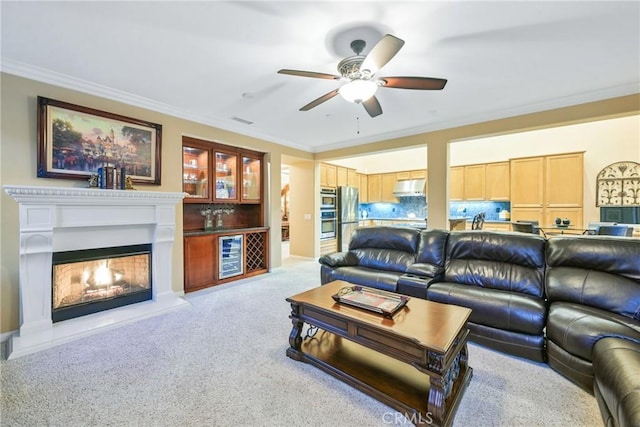 living room with ceiling fan, crown molding, wine cooler, and light carpet